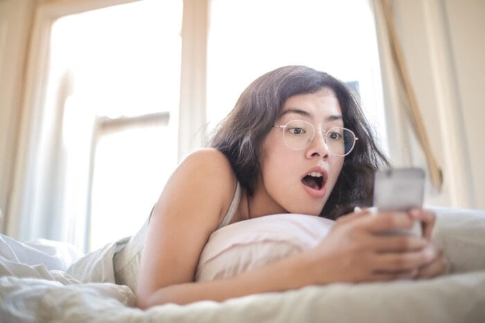shocked woman looking at smartphone